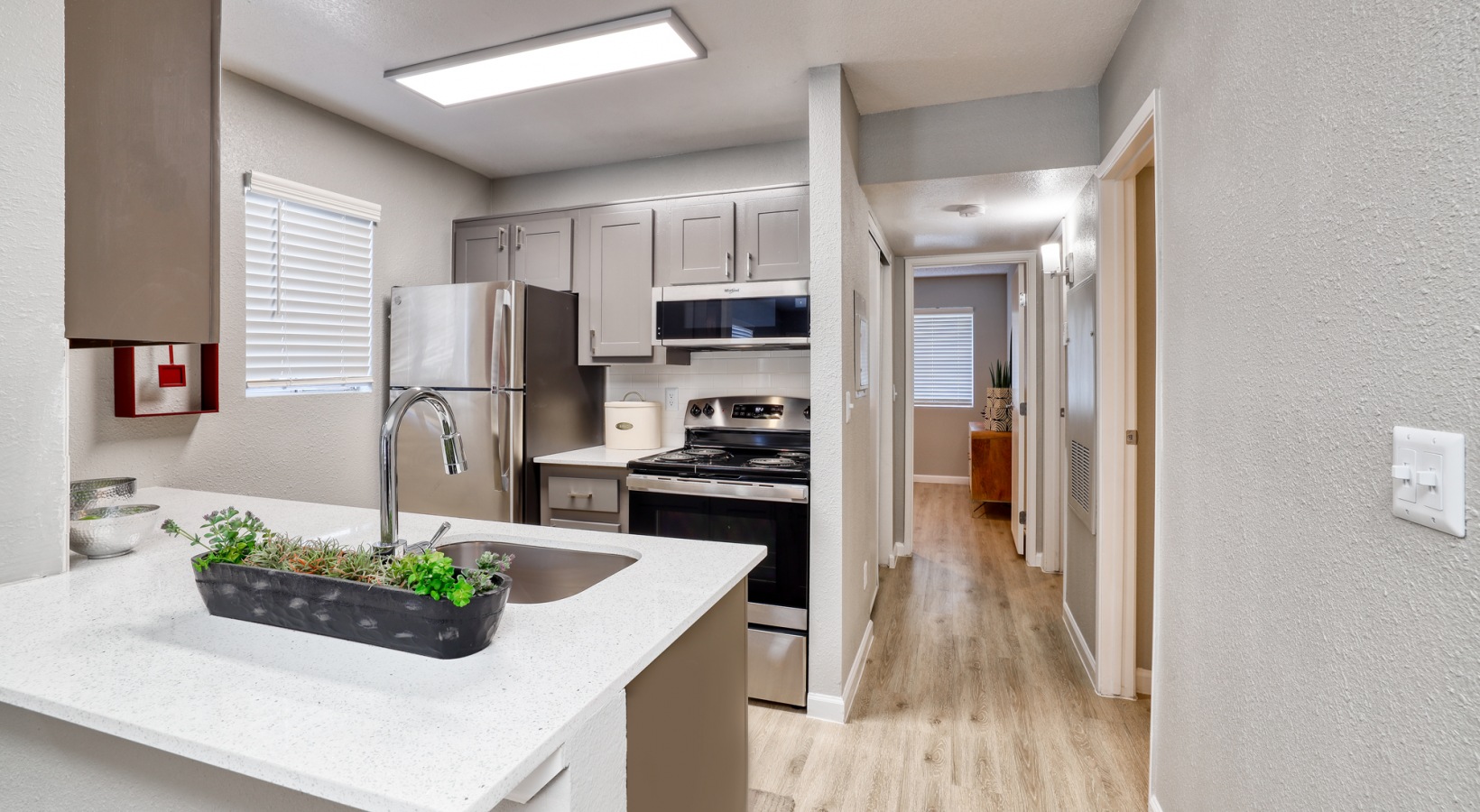 a kitchen with stainless steel appliances and wood floors at The Jerome