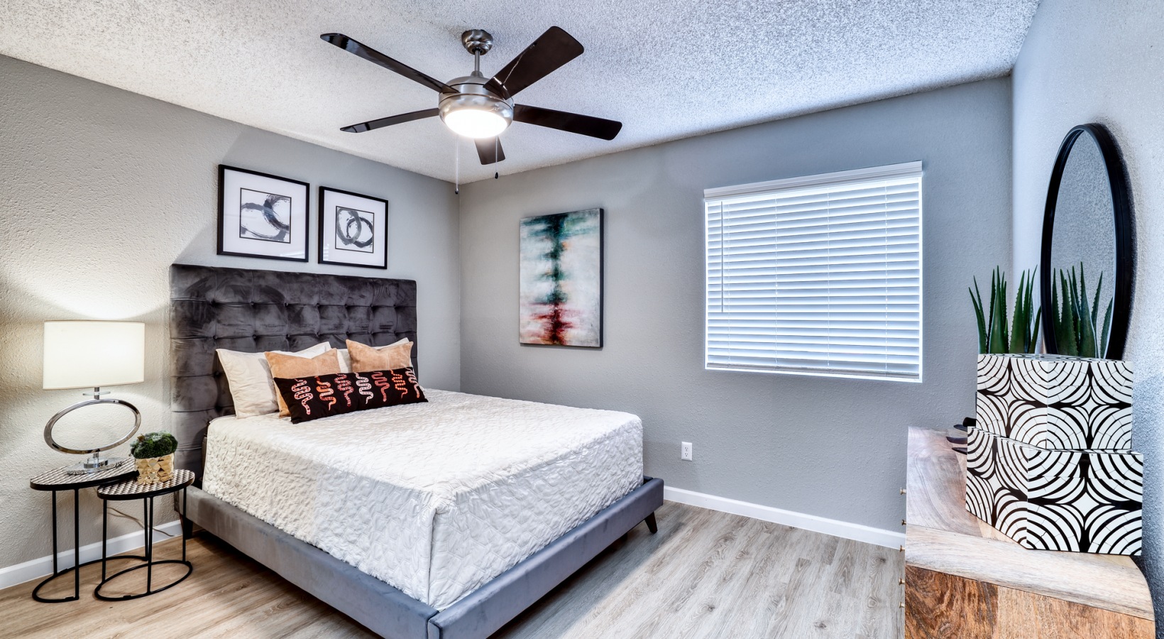 a bedroom with a ceiling fan and hardwood floors at The Jerome