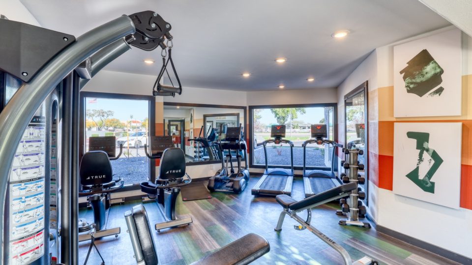a gym room with exercise equipment and mirrors at The Jerome