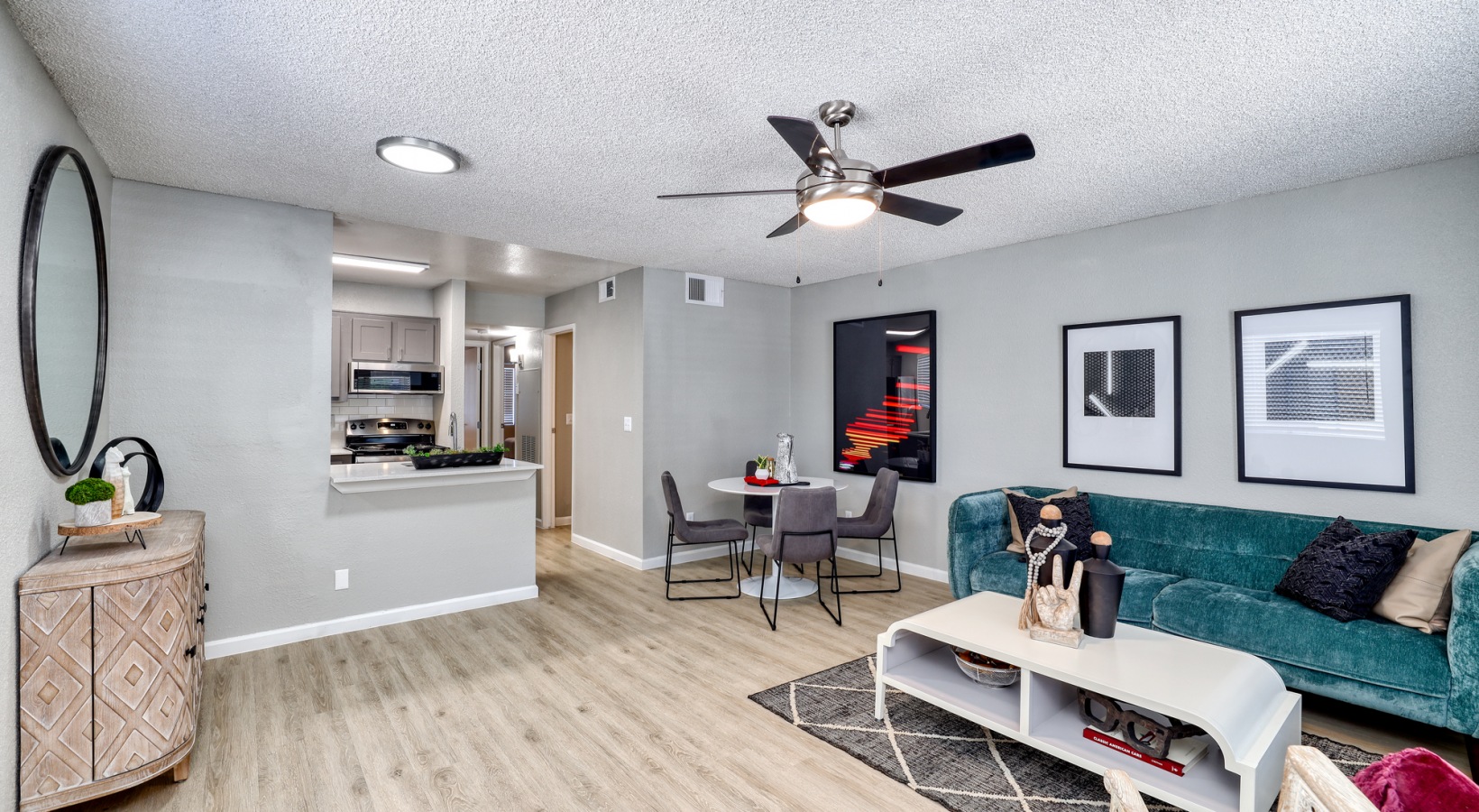 a living room with a ceiling fan and hardwood floors at The Jerome