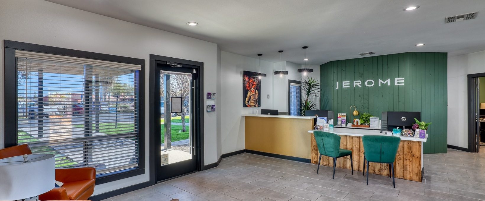 the lobby of a home with a green couch and orange chairs at The Jerome