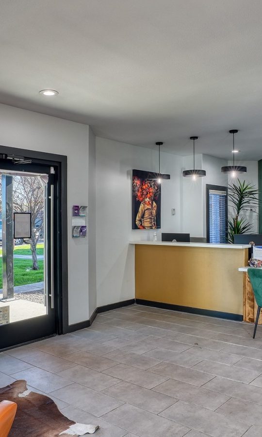 the lobby of a home with a green couch and orange chairs at The Jerome